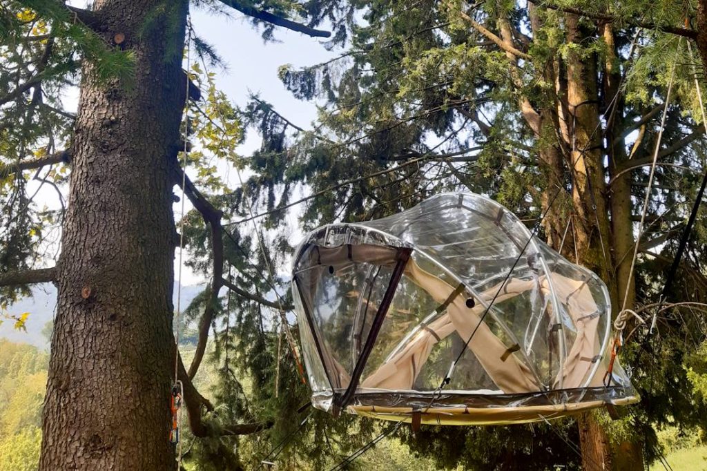 sfera trasparente tra gli alberi in Lombardia