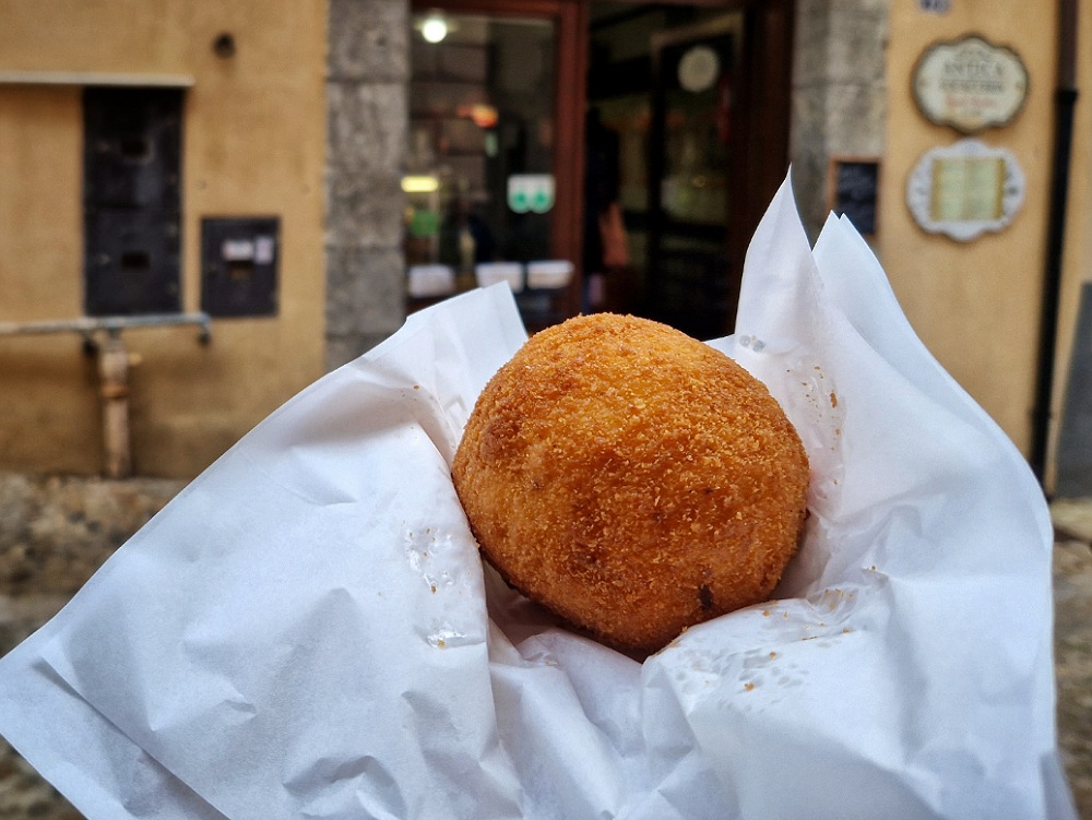 Un'arancina a Cefalù: street food a Palermo e dintorni